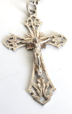 Decorative silver cross pendant on a white background