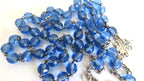 Blue rosary beads on a white background