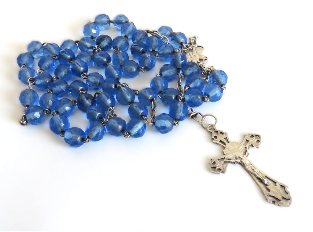 Blue rosary with a cross on a white background
