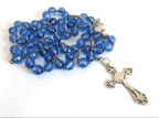 Blue rosary with a cross on a white background