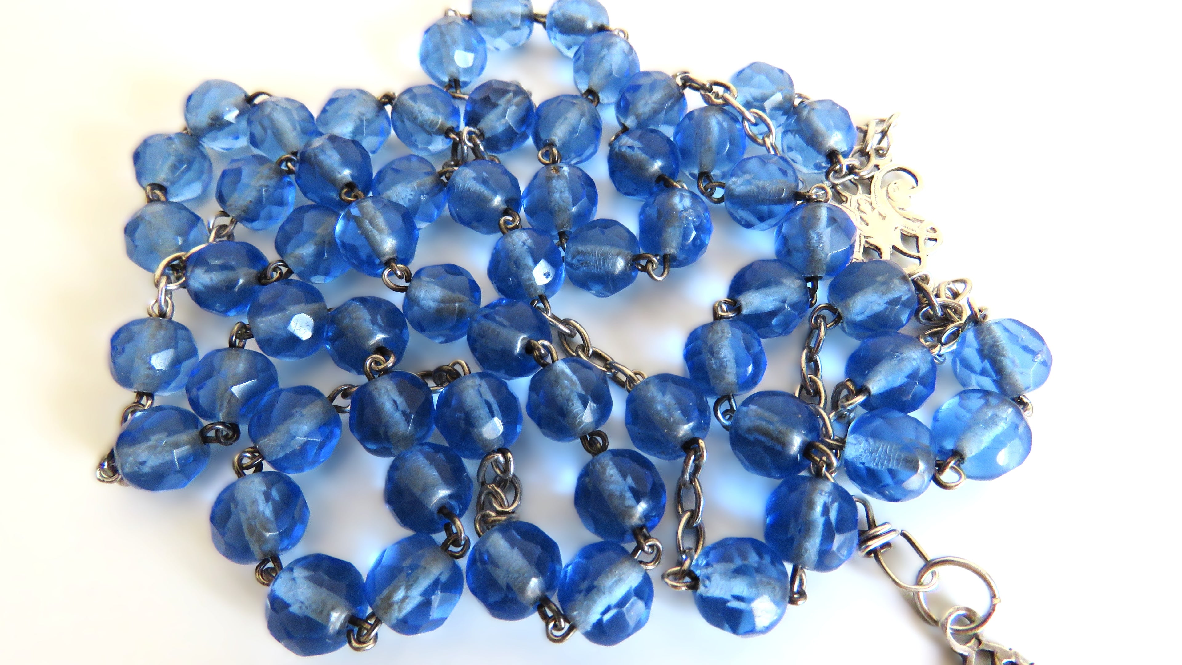 Blue beads rosary on a white background