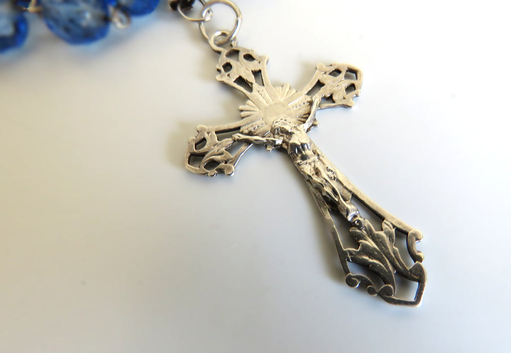 Decorative silver cross pendant on a white background