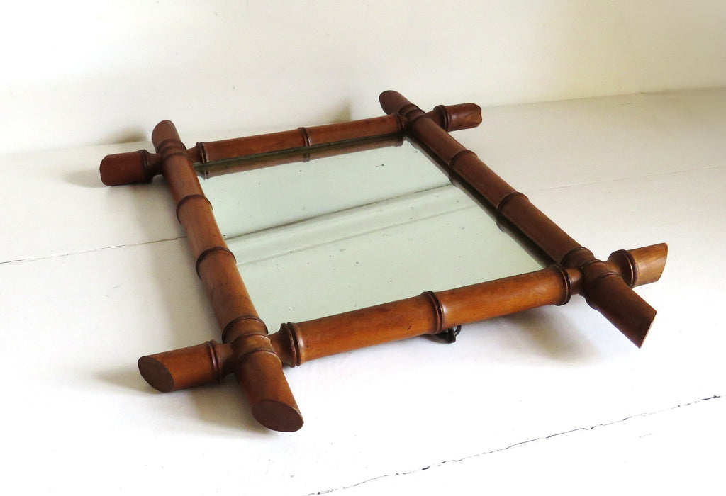 Small rectangular mirror with a bamboo-style frame on a white surface