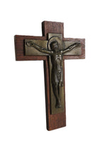 Wooden cross with a bronze figure of Jesus on a white background