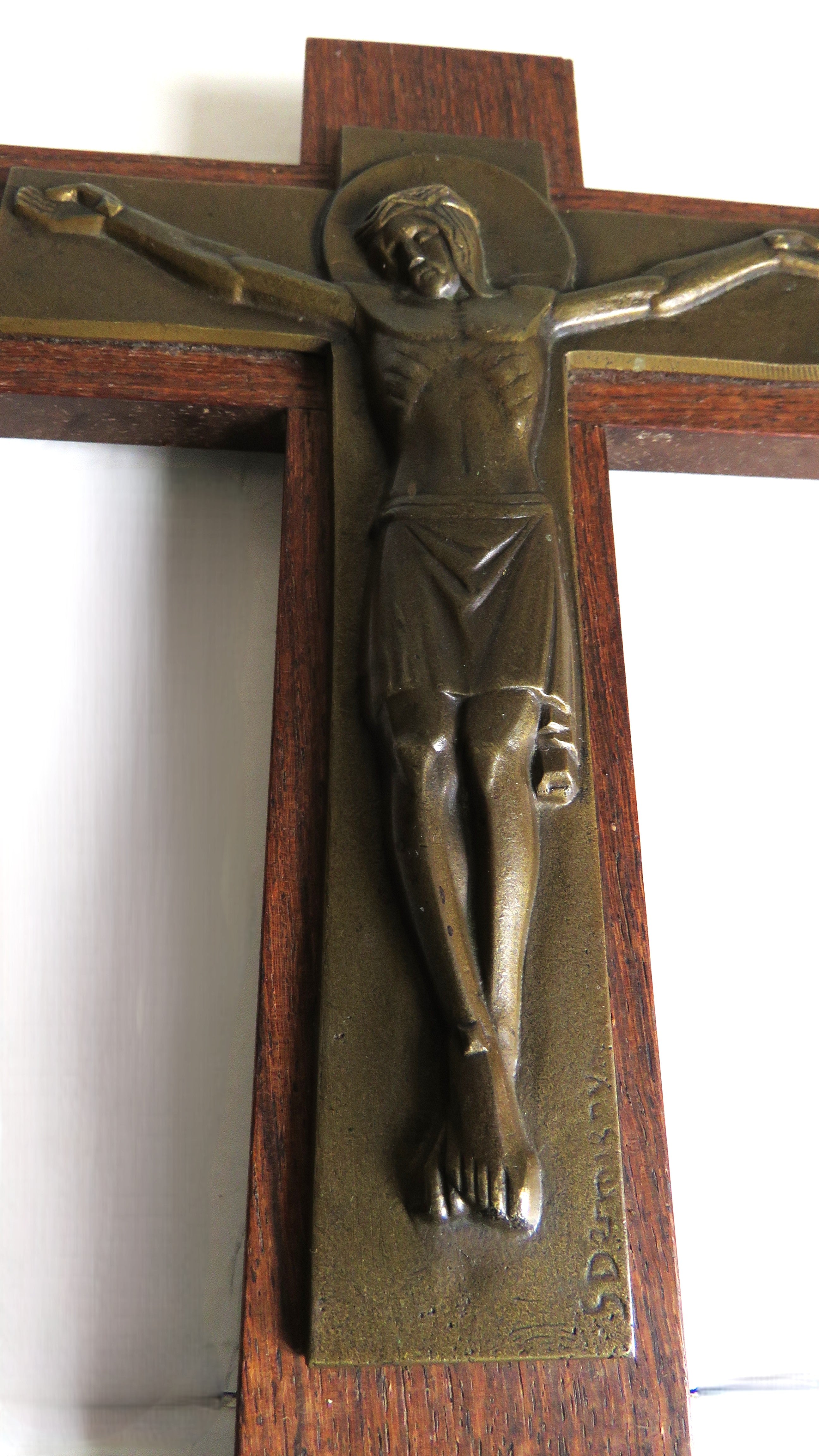 Bronze sculpture of a crucified Christ on a wooden cross