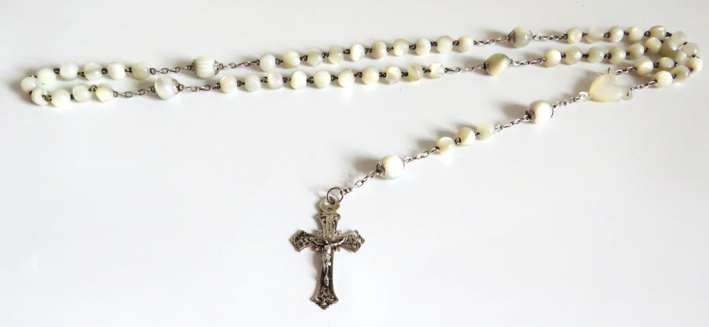 Mother of pearl rosary with silver crucifix on a wite background