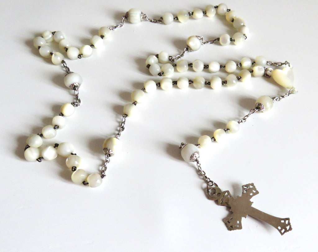 Mother of pearl rosary with silver crucifix on a wite background