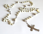 Mother of pearl rosary with silver crucifix on a wite background