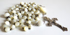 Mother of pearl rosary with silver crucifix on a wite background