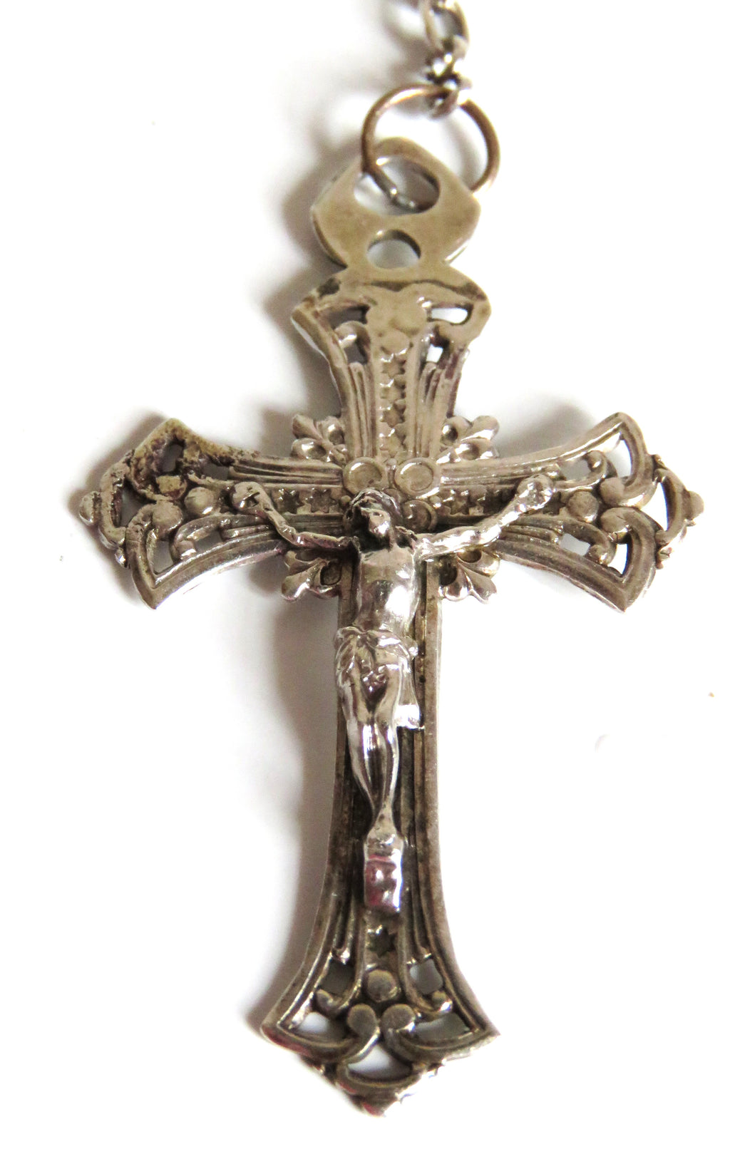 Decorative silver crucifix pendant on a white background