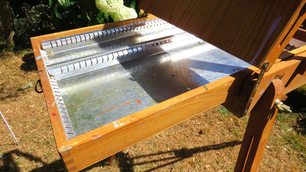 Inside view wooden artist's easel in a garden setting with grass