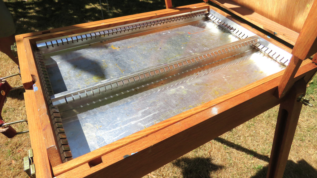 Inside drawer view wooden artist's easel in a garden setting 