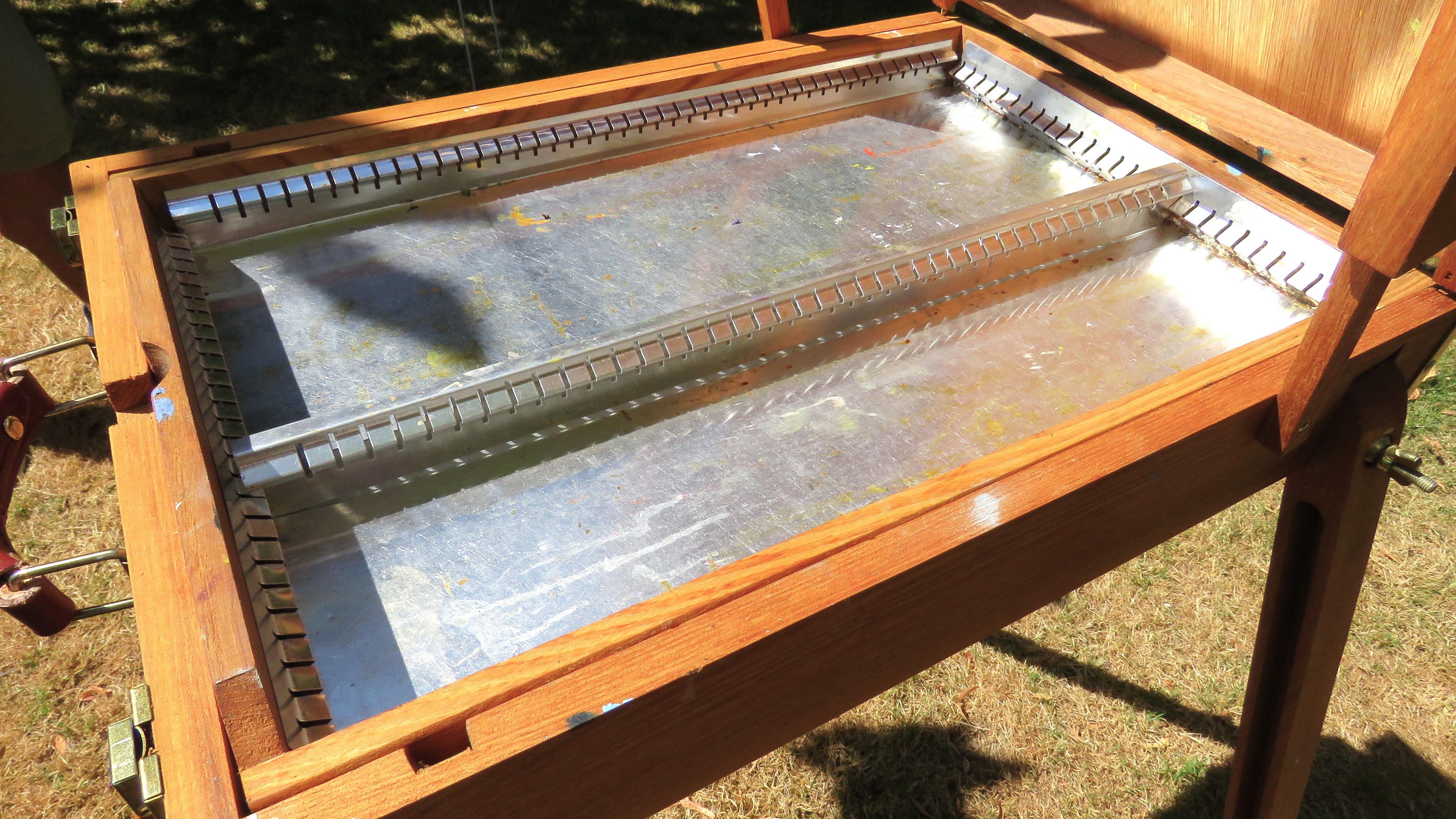 Inside drawer view wooden artist's easel in a garden setting 