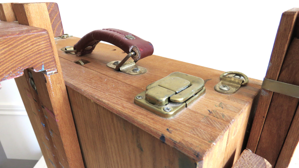 Close-up of a wooden box with metal clasps and a handle.