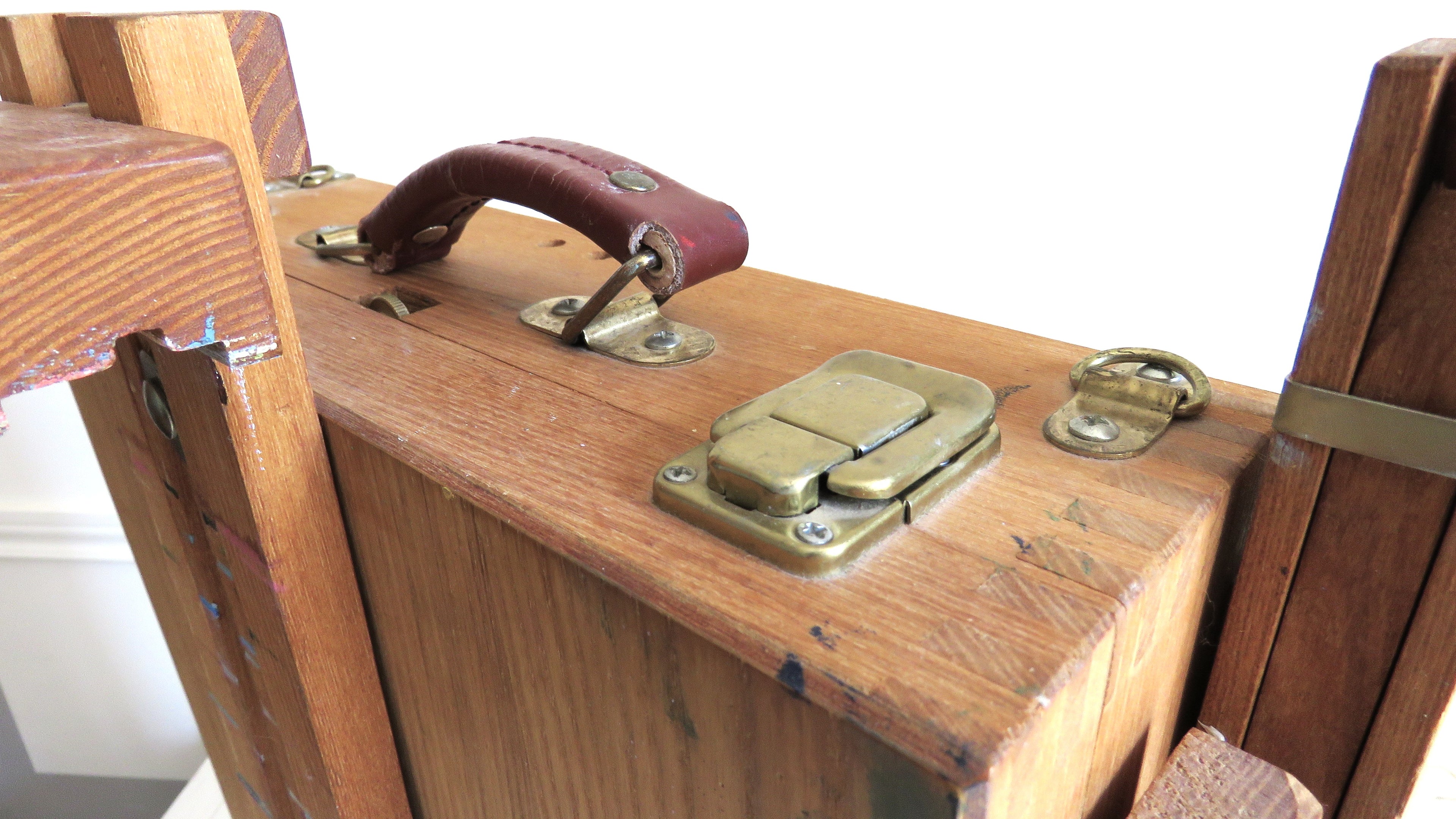 Close-up of a wooden box with metal clasps and a handle.