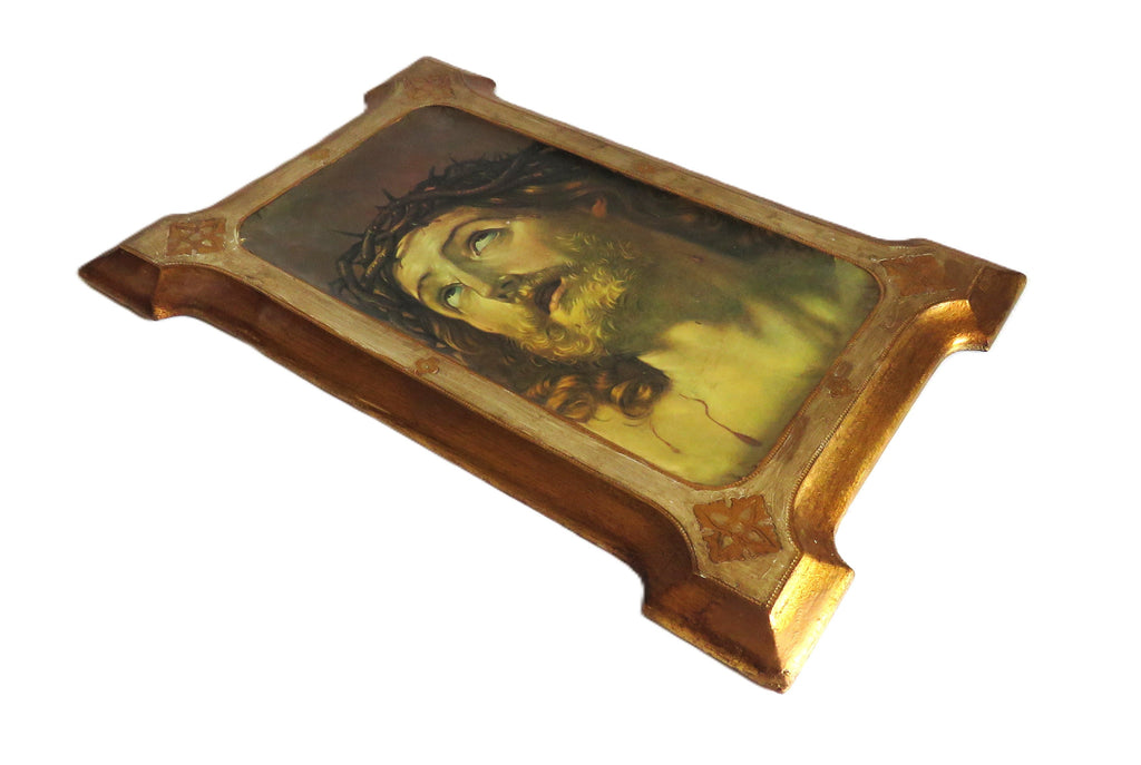 Decorative plaque with Christ design in a gold frame on a white background