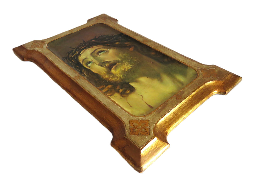 Decorative plaque with Christ design in a gold frame on a white background