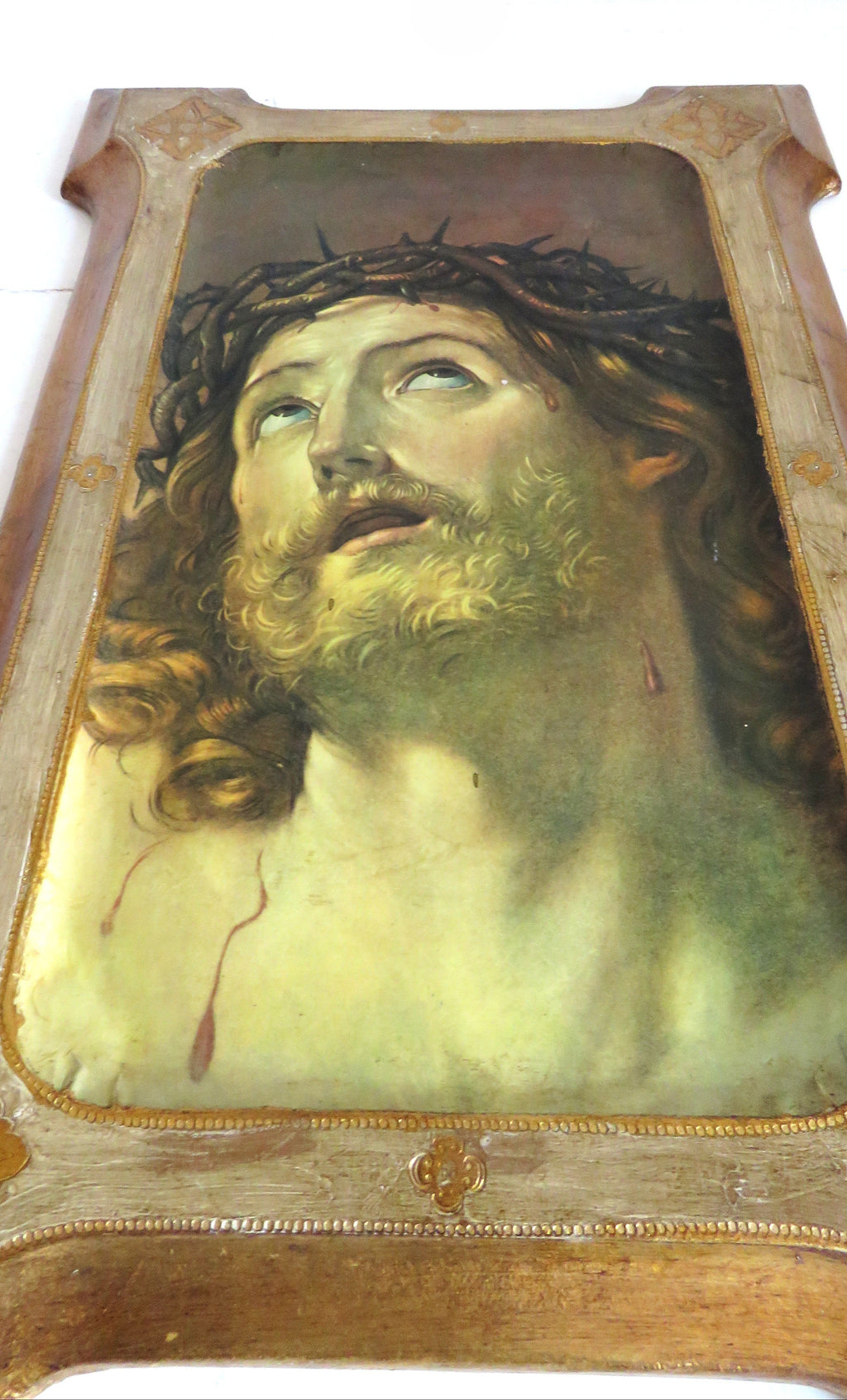Decorative plaque with Christ design in a gold frame on a white background