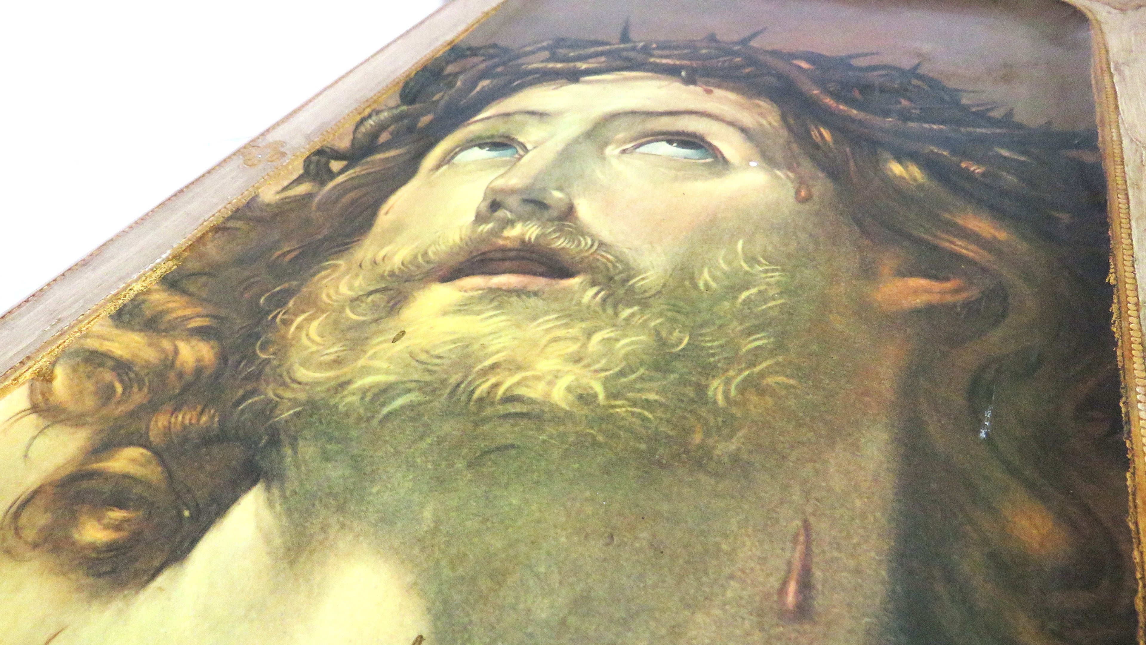 Close-up of a classical painting of a Christ with a crown of thorns.