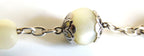 Close-up of a rosary with white pearl  beads and silver chain on a white background