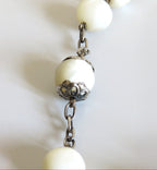 Pearl necklace with silver chain on a light background