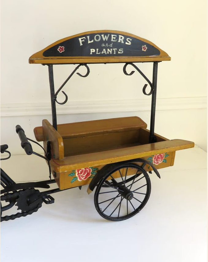 Vintage-style flower cart with 'Flowers & Plants' sign on a white background