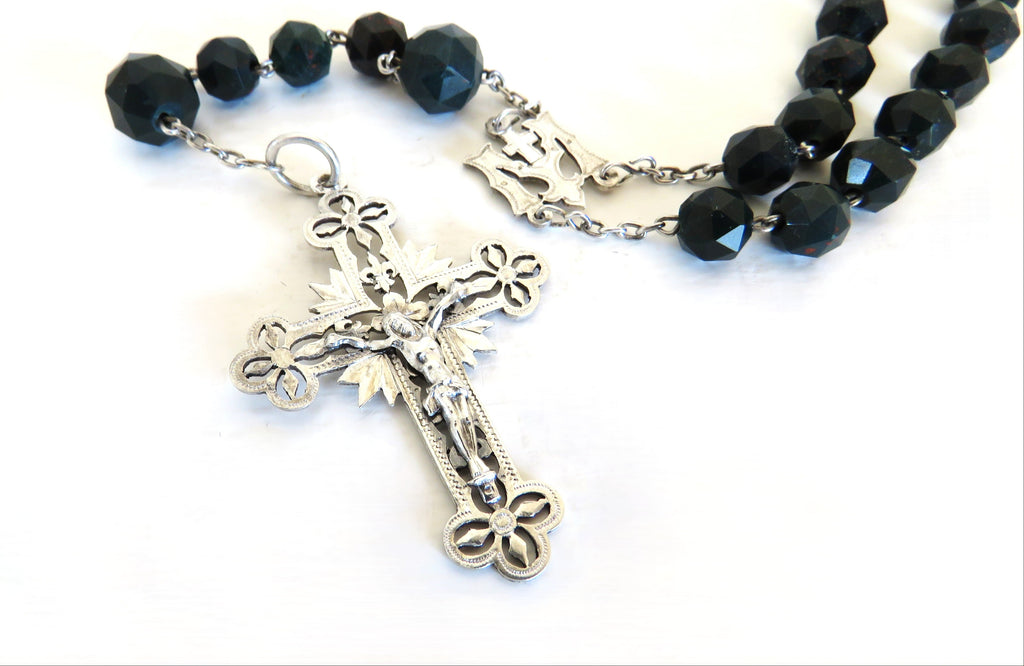 Bloodstone green rosary with a silver crucifix on a white background