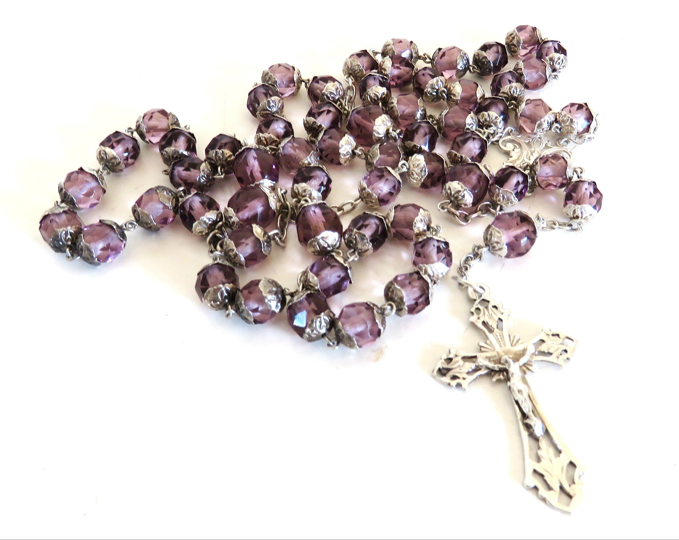 Purple and silver antique rosary on a white background