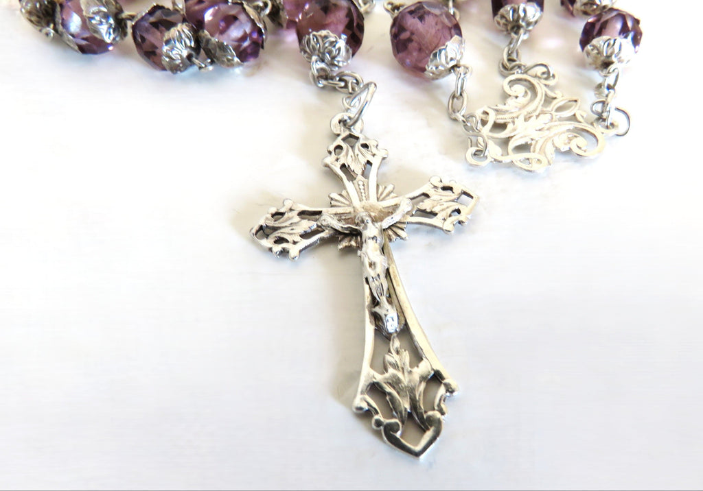 Silver rosary crucifix on a white background