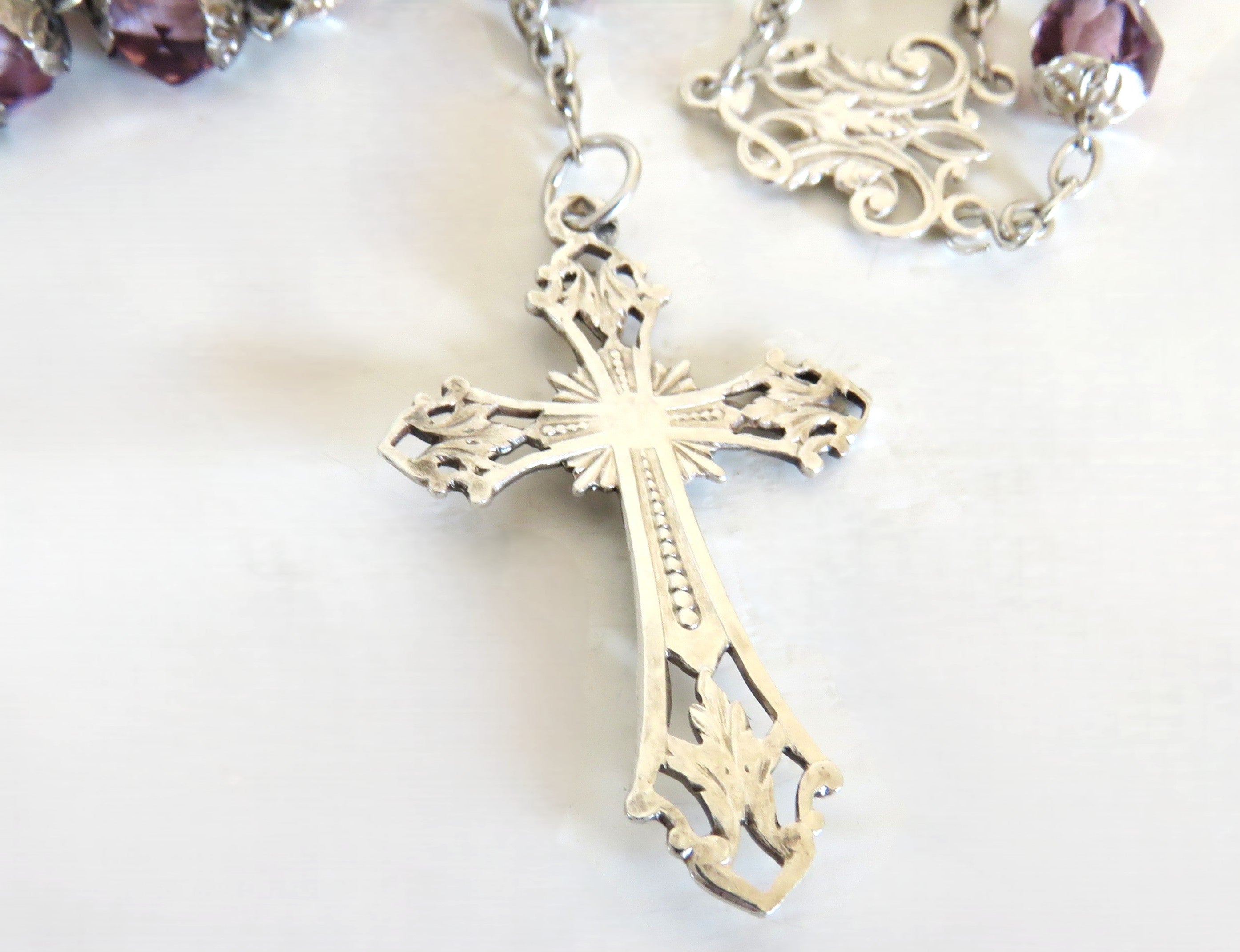 Back of a silver crucifix on a white background