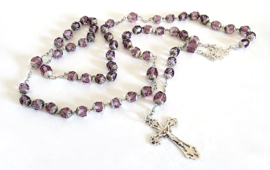 Purple and silver antique rosary on a white background