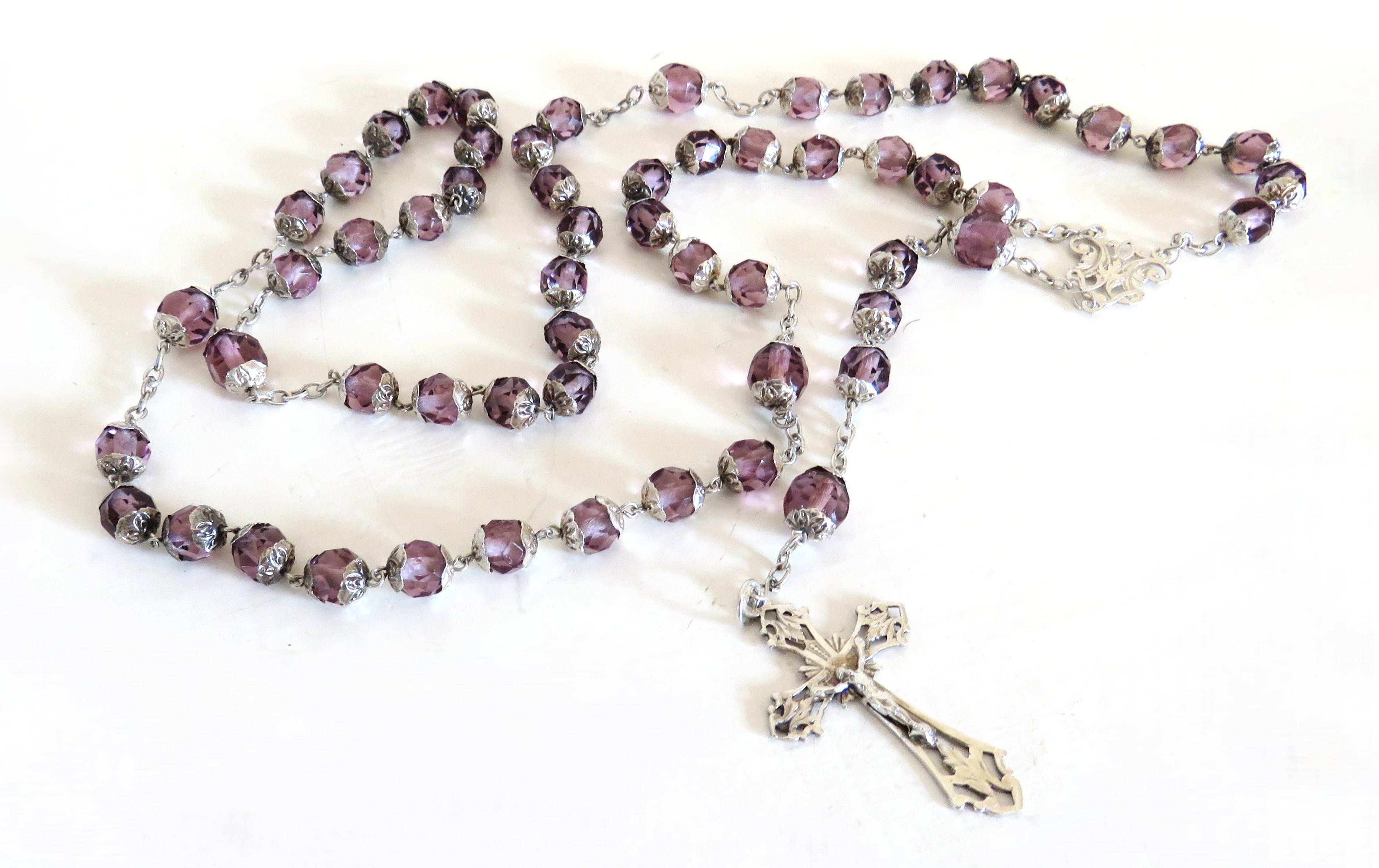 Purple and silver antique rosary on a white background