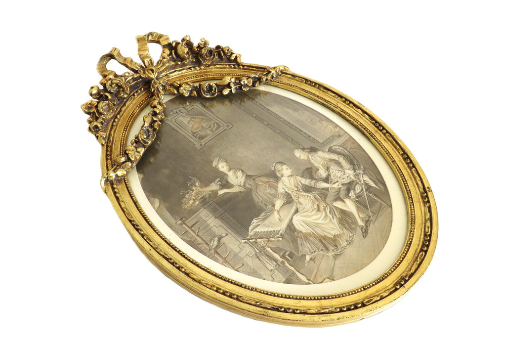 Decorative gold frame with a central oval image on a white background