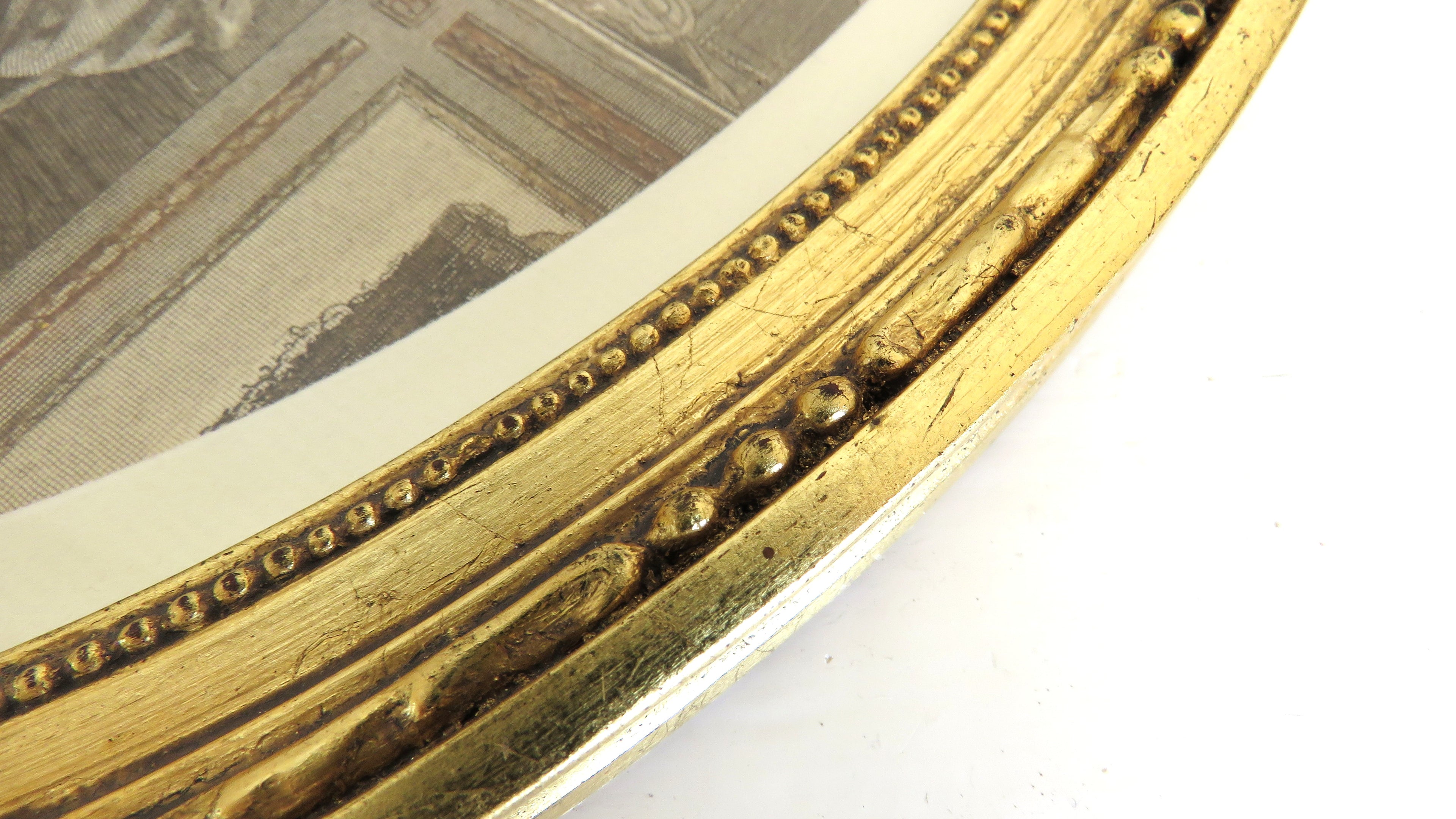 Close-up of a gold-framed picture with decorative detailing