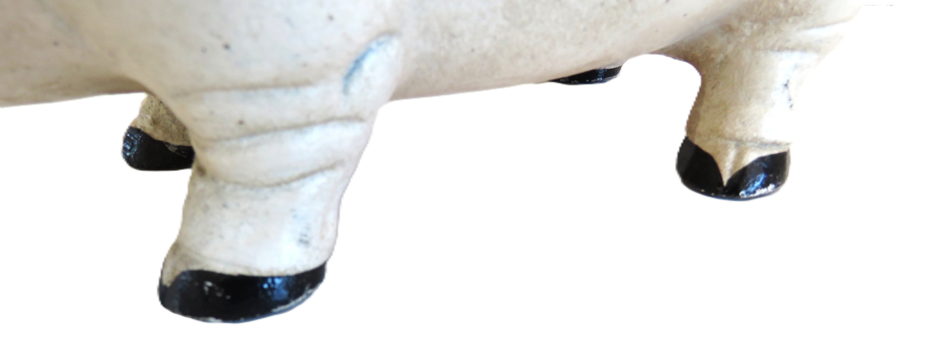 Close-up of a white pig figure with black hooves on a white background