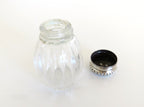 one silver and glass salt cellar with lid off on white background