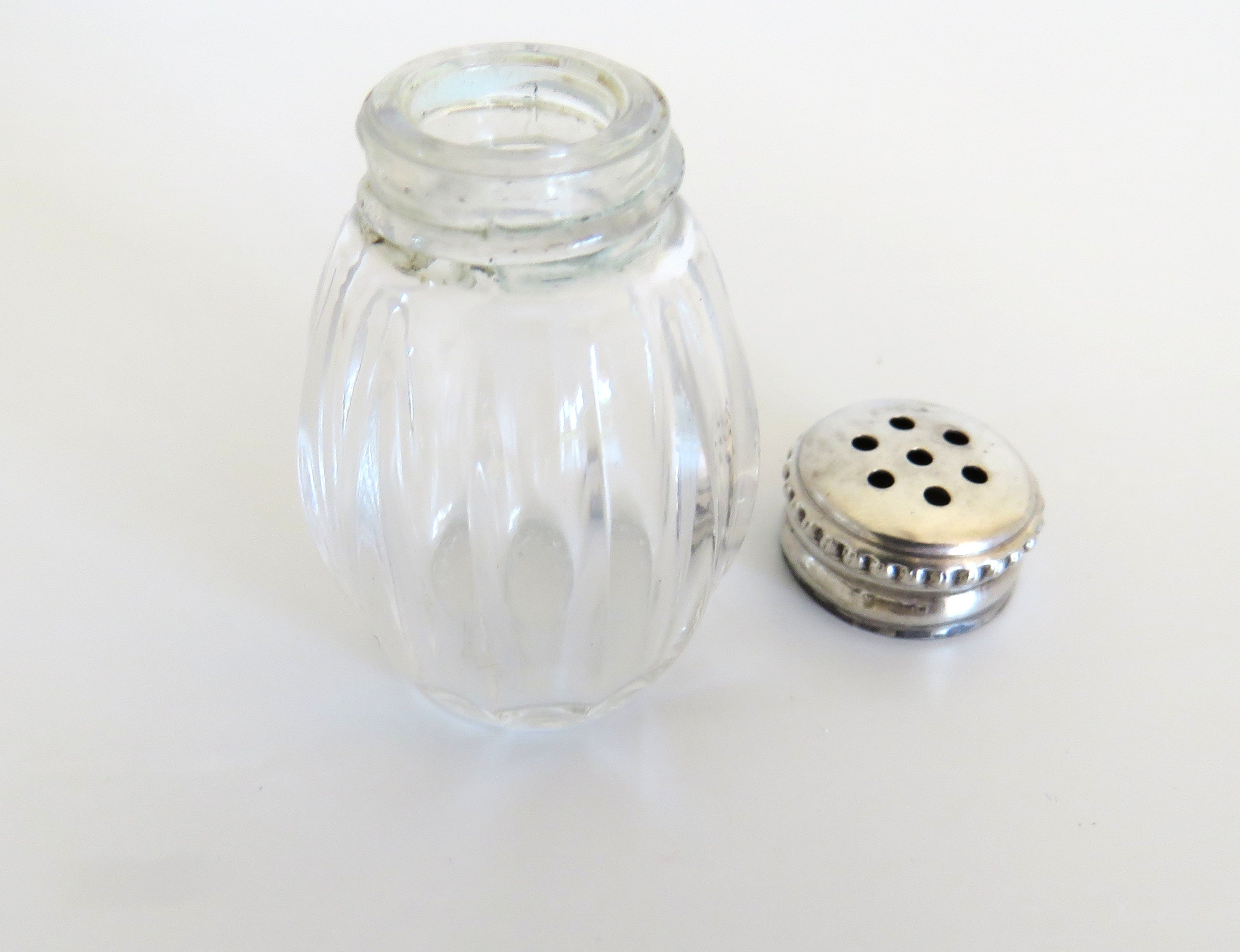 one silver and glass salt cellar with top off