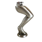 A cigarette lighter on a metallic silver sculpture of a bent leg wearing a high heel, standing on a round base against a plain white background.