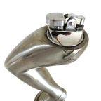 A cigarette lighter on a metallic silver sculpture of a bent leg wearing a high heel, standing on a round base against a plain white background.