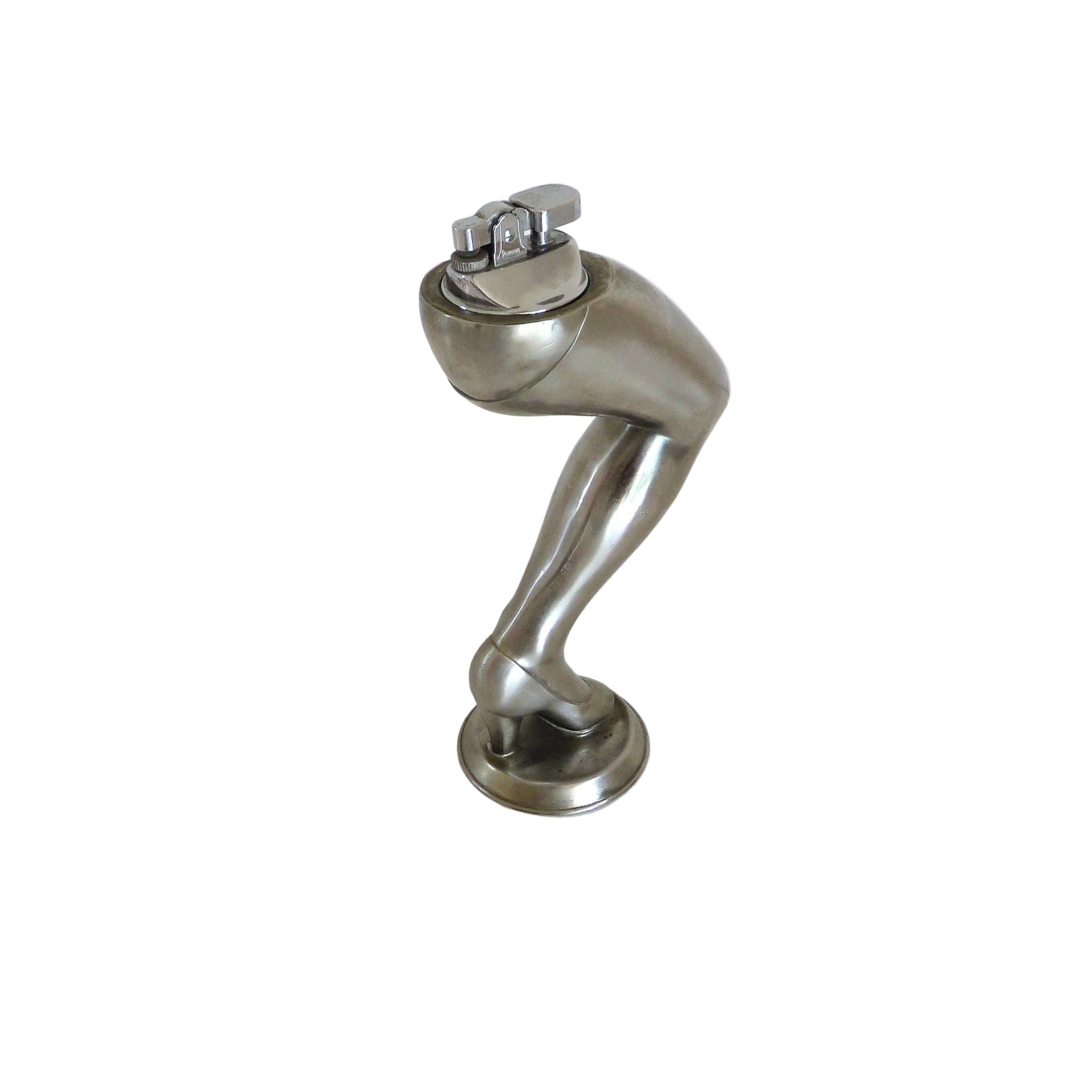 A cigarette lighter on a metallic silver sculpture of a bent leg wearing a high heel, standing on a round base against a plain white background.