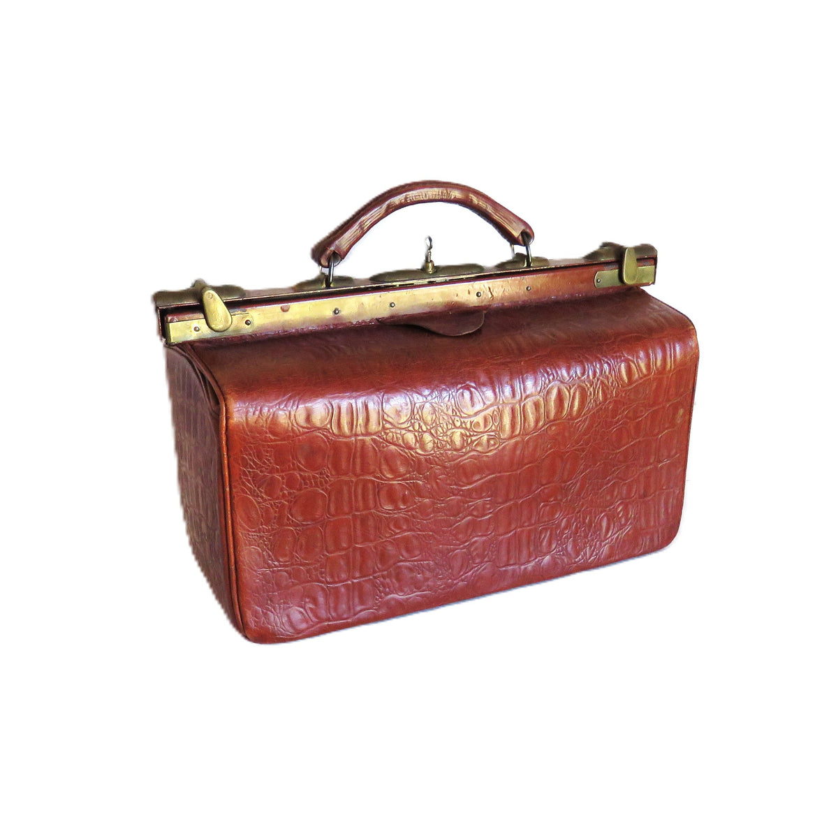 A vintage reddish-brown crocodile-embossed leather drs bag with a top handle and brass-tone clasp hardware, isolated on a white background.