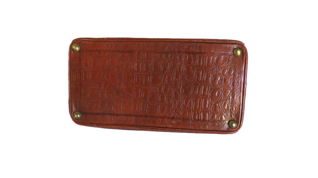 A brown crocodile-embossed leather bottom panel or mat with rounded corners and four brass-colored metal rivets, shown against a plain white background.