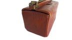 A vintage brown leather briefcase with an embossed crocodile pattern, brass hardware, and a top handle, shown on a plain white background.