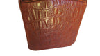 A close-up of a brown crocodile-embossed leather material, showing a glossy textured pattern on a plain white background.