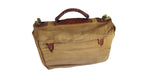 A vintage tan canvas satchel or briefcase-style bag with dark brown leather trim, a top handle, and brass-tone hardware, shown on a plain white background.