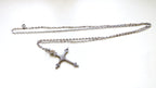 silver cross and chain on white background
