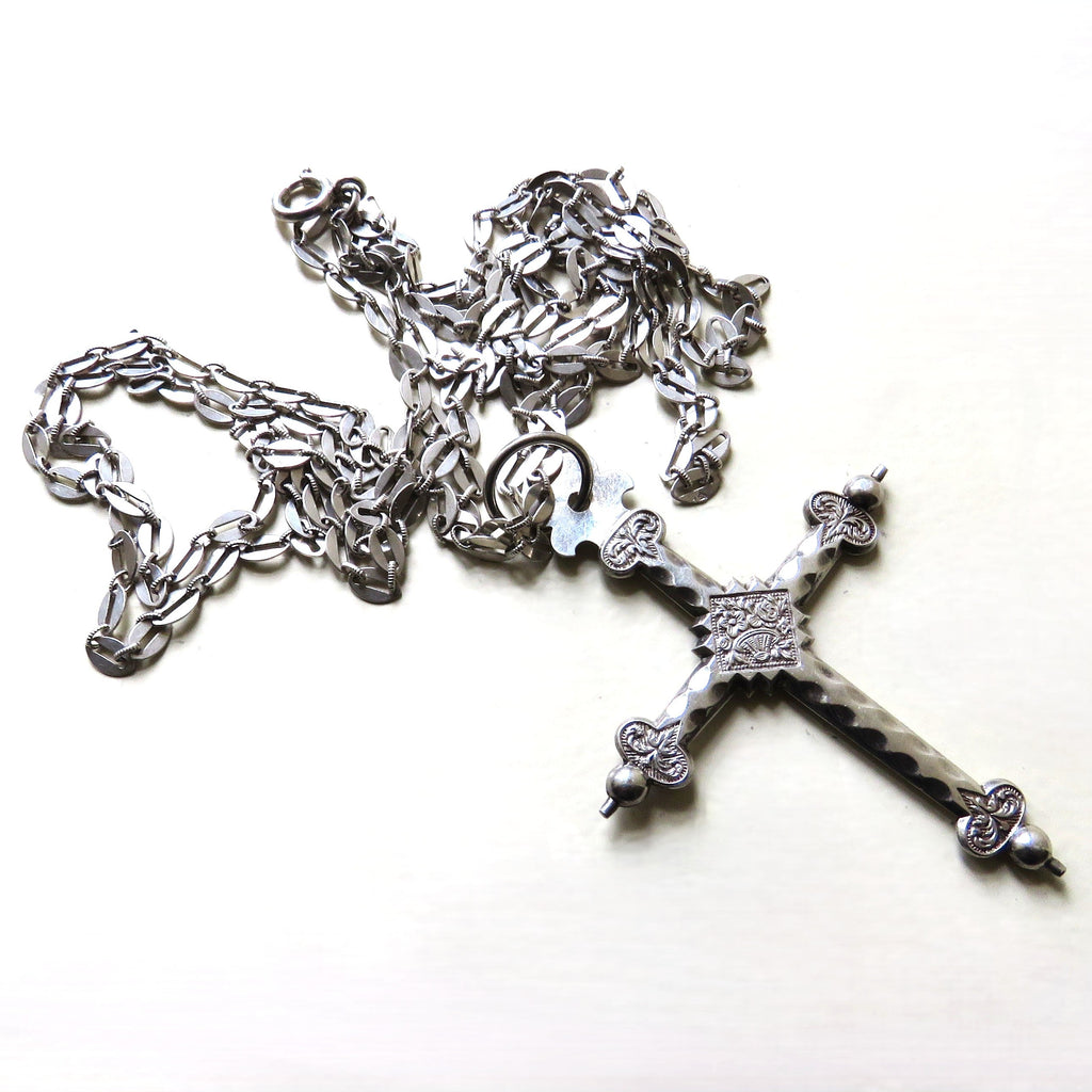 silver cross and chain on white background
