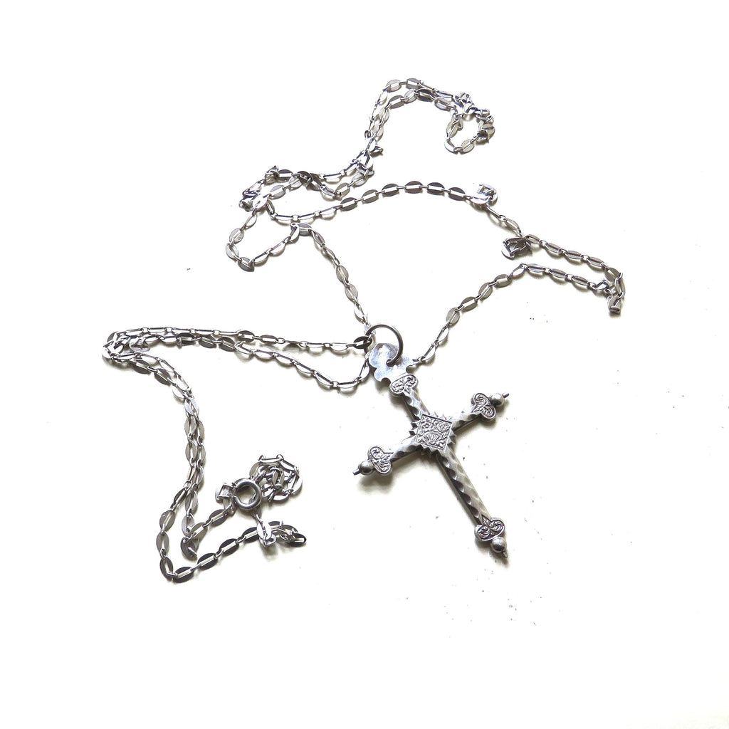 silver cross and chain on white background
