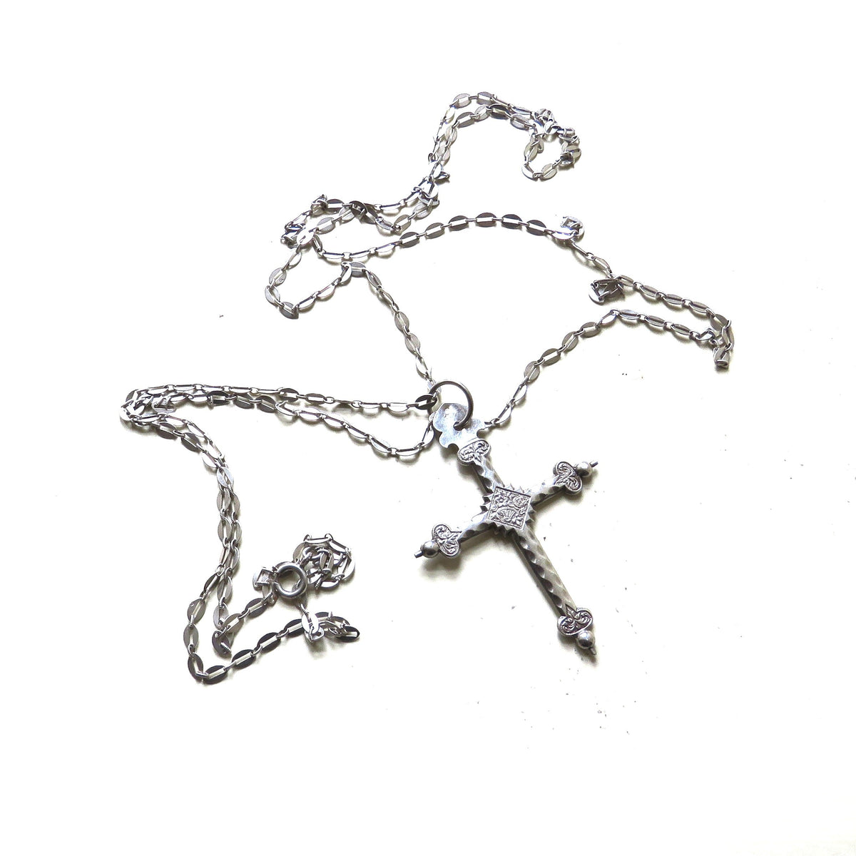 silver cross and chain on white background
