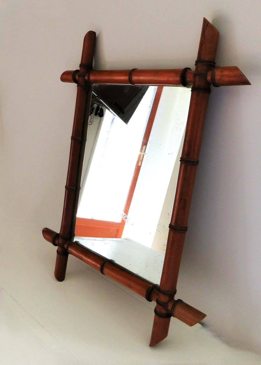 Wooden-framed mirror with a bamboo design on a white background
